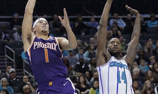 Phoenix Suns' Devin Booker (1) shoots after being fouled by Charlotte Hornets' Michael Kidd-Gilchri...