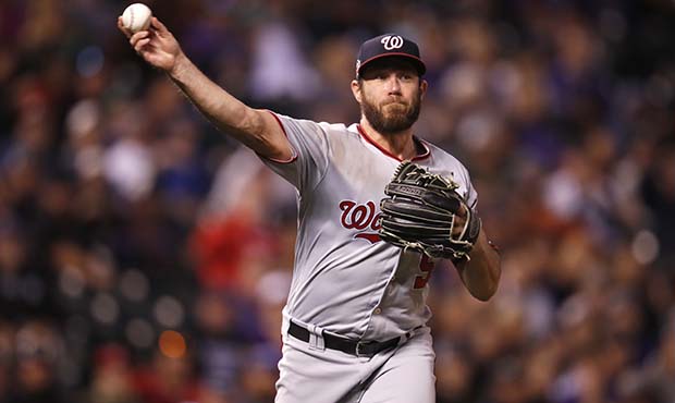 Washington Nationals relief pitcher Greg Holland throws to first base to put out Colorado Rockies' ...