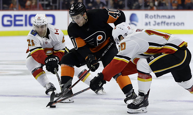 Philadelphia Flyers' Jordan Weal (40) battles for the puck with Calgary Flames' Garnet Hathaway (21...