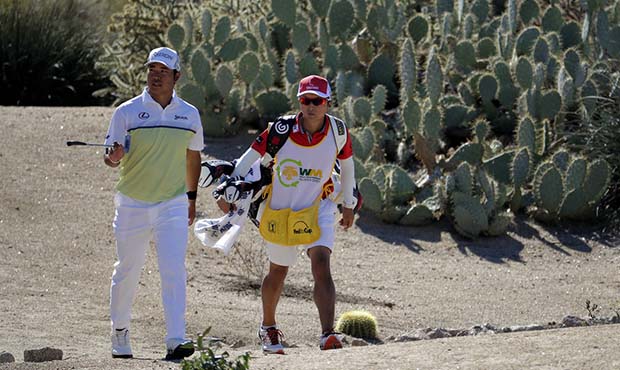 Hideki Matsuyama, of Japan, walks up to the fourth green with his caddie during the final round of ...
