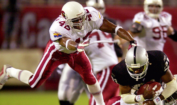 Arizona Cardinals' Kwamie Lassiter, left, and teammate Corey Chavous, rear, tackle Oakland Raiders'...
