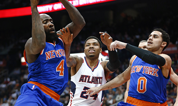 New York Knicks forward Quincy Acy (4) pulls down a rebound in front of Atlanta Hawks guard Kent Ba...