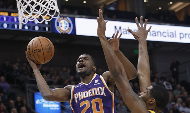 Phoenix Suns' Josh Jackson (20) attempts a layup as Utah Jazz forward Derrick Favors, right, defend...