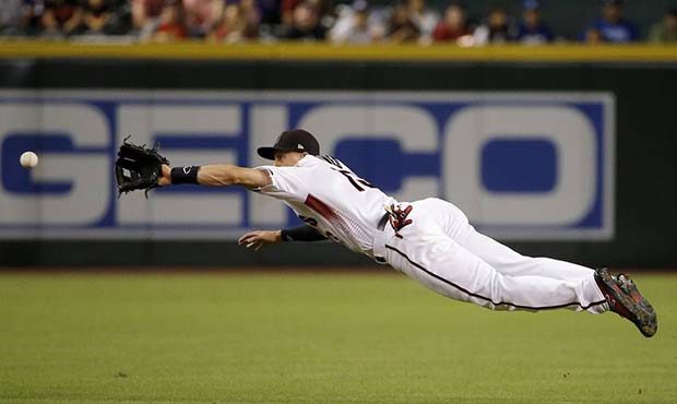 Arizona Diamondbacks shortstop Nick Ahmed reaches out to field a grounder hit by Los Angeles Dodger...