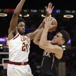 Phoenix Suns' Devin Booker (1) drives past Cleveland Cavaliers' Brandon Knight (20) in the second half of an NBA basketball game, Thursday, Feb. 21, 2019, in Cleveland. (AP Photo/Tony Dejak)