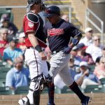 Cleveland Indians' Jose Ramirez scores on a double by Kevin Plawecki as Arizona Diamondbacks catcher Carson Kelly stands near the plate during the first inning of a spring training baseball game Thursday, Feb. 28, 2019, in Scottsdale, Ariz. (AP Photo/Matt York)