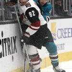 Arizona Coyotes defenseman Jordan Oesterle (82) is checked into the boards by San Jose Sharks right wing Barclay Goodrow (23) during the first period of an NHL hockey game in San Jose, Calif., Saturday, Feb. 2, 2019. (AP Photo/Tony Avelar)