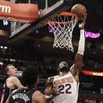 Phoenix Suns center Deandre Ayton (22) shoots and scores against Miami Heat forward Duncan Robinson (55) and Miami Heat center Hassan Whiteside (21) during the first half of an NBA basketball game Monday, Feb. 25, 2019, in Miami. (AP Photo/Brynn Anderson)