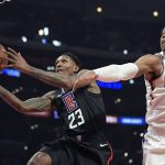 Los Angeles Clippers guard Lou Williams, left, shoots as Phoenix Suns forward Richaun Holmes defends during the first half of an NBA basketball game Wednesday, Feb. 13, 2019, in Los Angeles. (AP Photo/Mark J. Terrill)