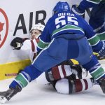Vancouver Canucks' Alex Biega, front, checks Arizona Coyotes' Vinnie Hinostroza during the second period of an NHL hockey game Thursday, Feb. 21, 2019, in Vancouver, British Columbia. (Darryl Dyck/The Canadian Press via AP)