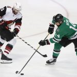 Arizona Coyotes defenseman Alex Goligoski (33) and Dallas Stars left wing Jamie Benn (14) vied for control of the puck during the first period of an NHL hockey game in Dallas, Monday, Feb. 4, 2019. (AP Photo/LM Otero)