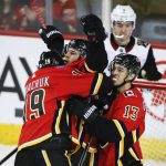 Calgary Flames' Mark Giordano, centre, celebrates his goal with teammates Matthew Tkachuk, left, and Johnny Gaudreau during second period NHL hockey action against the Arizona Coyotes in Calgary, Alberta, Monday, Feb. 18, 2019. (Jeff McIntosh/The Canadian Press via AP)