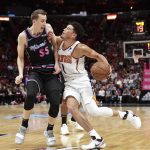 Miami Heat forward Duncan Robinson (55) fouls Phoenix Suns guard Devin Booker (1) during the first half of an NBA basketball game on Monday, Feb. 25, 2019, in Miami. (AP Photo/Brynn Anderson)
