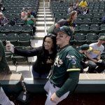 A fan takes a picture with Oakland Athletics first baseman Mark Canha before a spring baseball game against the Arizona Diamondbacks in Scottsdale, Ariz., Monday, Feb. 25, 2019. (AP Photo/Chris Carlson)