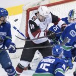 The puck goes wide of the net as Arizona Coyotes' Jordan Weal (10) checks Vancouver Canucks' Alex Biega (55) in front of goalie Jacob Markstrom, back right, of Sweden, as Derrick Pouliot, left, and Ryan Spooner watch during the second period of an NHL hockey game Thursday, Feb. 21, 2019, in Vancouver, British Columbia. (Darryl Dyck/The Canadian Press via AP)