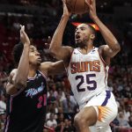 Phoenix Suns forward Mikal Bridges (25) scores against Miami Heat center Hassan Whiteside (21) during the first half of an NBA basketball game Monday, Feb. 25, 2019, in Miami. (AP Photo/Brynn Anderson)