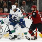 Vancouver Canucks defenseman Alexander Edler (23) watches the puck move past his head as Arizona Coyotes center Brad Richardson (15) looks for a rebound while Canucks goaltender Thatcher Demko, left, is screened from the play during the first period of an NHL hockey game Thursday, Feb. 28, 2019, in Glendale, Ariz. (AP Photo/Ross D. Franklin)