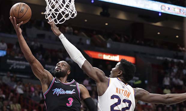 Miami Heat guard Dwyane Wade (3) shoots the ball against Phoenix Suns center Deandre Ayton (22) dur...
