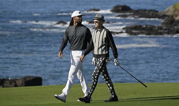 Larry Fitzgerald Jr., left, and Adrian Young walk down the ninth fairway of the Pebble Beach Golf L...