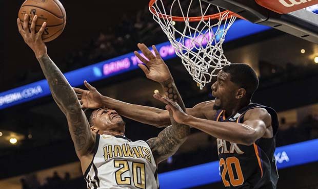 Atlanta Hawks forward John Collins (20) shoots as Phoenix Suns forward Josh Jackson (20) defends du...