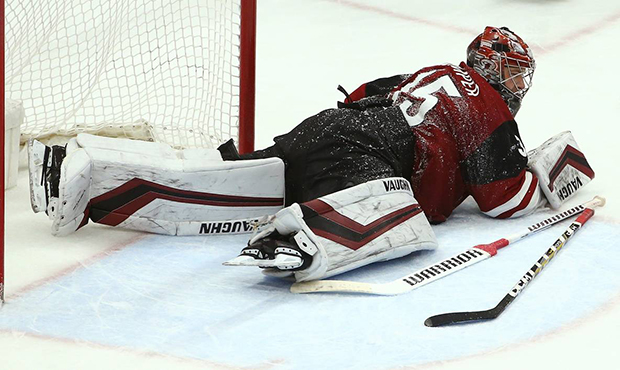 Arizona Coyotes goaltender Darcy Kuemper tries to get back up after being hit on the helmet by St. ...
