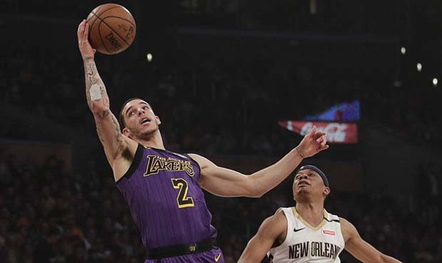 Los Angeles Lakers' Lonzo Ball, left, grabs a pass next to New Orleans Pelicans' Tim Frazier during...