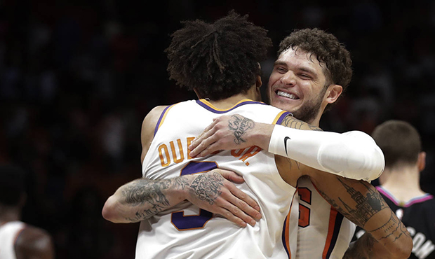 Phoenix Suns guard Tyler Johnson (16) hugs Phoenix Suns forward Kelly Oubre Jr. (3) after winning a...
