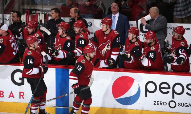 Vinnie Hinostroza #13 of the Arizona Coyotes celebrates with teammates on the bench after scoring a...