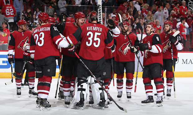 Goaltender Darcy Kuemper #35 of the Arizona Coyotes is congratulated by Lawson Crouse #67 and teamm...