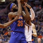 New York Knicks center Mitchell Robinson (26) shoots as Phoenix Suns forward Richaun Holmes defends during the first half of an NBA basketball game Wednesday, March 6, 2019, in Phoenix. (AP Photo/Matt York)