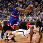 New York Knicks guard Emmanuel Mudiay (1) fouls Phoenix Suns forward Josh Jackson (20) during the first half of an NBA basketball game Wednesday, March 6, 2019, in Phoenix. (AP Photo/Matt York)
