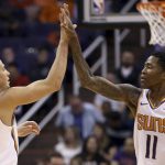 Phoenix Suns guard Devin Booker (1) celebrates his dunk against the Washington Wizards with guard Jamal Crawford (11) during the first half of an NBA basketball game Wednesday, March 27, 2019, in Phoenix. (AP Photo/Ross D. Franklin)