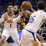 Utah Jazz guard Ricky Rubio (3) drives as Phoenix Suns guard Devin Booker (1) and guard Tyler Johnson (16) defend during the first half of an NBA basketball game, Wednesday, March 13, 2019, in Phoenix. (AP Photo/Matt York)