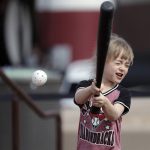 Arizona Diamondbacks fan Joslien Jewett, 5, swings but misses in an area for children to give skills a go, during a spring training baseball game between the Diamondbacks and the Cleveland Indians on Thursday, March 7, 2019, in Scottsdale, Ariz. (AP Photo/Elaine Thompson)