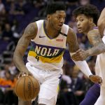 New Orleans Pelicans guard Elfrid Payton (4) gets held by Phoenix Suns forward Kelly Oubre Jr. in the first half during an NBA basketball game, Friday, March 1, 2019, in Phoenix. (AP Photo/Rick Scuteri)