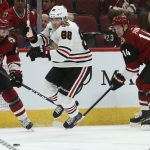 Chicago Blackhawks right wing Patrick Kane (88) gets tripped up by Arizona Coyotes right wing Richard Panik (14) as Coyotes center Brad Richardson (15) looks for the puck during the first period of an NHL hockey game Tuesday, March 26, 2019, in Glendale, Ariz. (AP Photo/Ross D. Franklin)