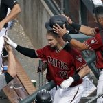 Arizona Diamondbacks' David Peralta (6) removes the batting helmet of Caleb Joseph as Joseph heads into the dugout for congratulations following solo home run against the Cleveland Indians in the fifth inning of a spring training baseball game Thursday, March 7, 2019, in Scottsdale, Ariz. (AP Photo/Elaine Thompson)