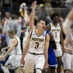 Wofford guard Fletcher Magee (3) celebrates with teammates after hitting a 3-point basket during the final moments of the second half against Seton Hall in a first-round game in the NCAA men's college basketball tournament in Jacksonville, Fla. Thursday, March 21, 2019. (AP Photo/Stephen B. Morton)