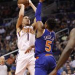 Phoenix Suns guard Devin Booker (1) shoots over New York Knicks guard Dennis Smith Jr. (5) during the second half of an NBA basketball game Wednesday, March 6, 2019, in Phoenix. (AP Photo/Matt York)