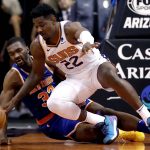 Phoenix Suns center Deandre Ayton (22) and New York Knicks forward Noah Vonleh (32) scramble for a loose ball during the first half of an NBA basketball game Wednesday, March 6, 2019, in Phoenix. (AP Photo/Matt York)