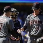 Arizona Diamondbacks starting pitcher Zack Greinke, right, is taken out of a baseball game by manager Torey Lovullo, left, as catcher John Ryan Murphy watches during the fourth inning against the Los Angeles Dodgers, Thursday, March 28, 2019, in Los Angeles. (AP Photo/Mark J. Terrill)