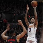 Phoenix Suns forward Kelly Oubre Jr., right, shoots as Portland Trail Blazers guard CJ McCollum defends during the first half of an NBA basketball game in Portland, Ore., Saturday, March 9, 2019. (AP Photo/Steve Dipaola)
