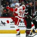 Detroit Red Wings center Dylan Larkin (71) celebrates his goal with Red Wings' Andreas Athanasiou, center, as Arizona Coyotes left wing Lawson Crouse (67) skates past during the second period of an NHL hockey game Saturday, March 2, 2019, in Glendale, Ariz. (AP Photo/Ross D. Franklin)