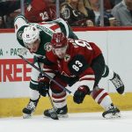 Arizona Coyotes right wing Conor Garland (83) battles with Minnesota Wild center Joel Eriksson Ek (14) for the puck during the first period of an NHL hockey game Sunday, March 31, 2019, in Glendale, Ariz. (AP Photo/Ross D. Franklin)