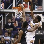 Phoenix Suns center Deandre Ayton (22) dunks over Washington Wizards center Thomas Bryant (13) as Wizards forward Troy Brown Jr., right, watches during the second half of an NBA basketball game Wednesday, March 27, 2019, in Phoenix. The Wizards won 124-121. (AP Photo/Ross D. Franklin)