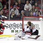 New Jersey Devils center Blake Coleman (20) trips over Arizona Coyotes goaltender Darcy Kuemper (35) while scoring during a shootout in an NHL hockey game, Saturday, March 23, 2019, in Newark, N.J. The Devils on 2-1 in a shootout. (AP Photo/Julio Cortez)