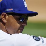 Los Angeles Dodgers manager Dave Roberts watches from the dugout while wearing a patch to honor Hall of Fame pitcher Don Newcombe during the first inning of a baseball game against the Arizona Diamondbacks, Thursday, March 28, 2019, in Los Angeles. Newcombe passed away on Feb. 19th. (AP Photo/Mark J. Terrill)