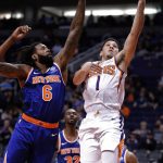 Phoenix Suns guard Devin Booker (1) shoots next to New York Knicks center DeAndre Jordan (6) during the second half of an NBA basketball game Wednesday, March 6, 2019, in Phoenix. (AP Photo/Matt York)