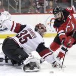 Arizona Coyotes goaltender Darcy Kuemper (35) tries to make a save as New Jersey Devils right wing Kyle Palmieri (21) attacks during the second period of an NHL hockey game, Saturday, March 23, 2019, in Newark, N.J. (AP Photo/Julio Cortez)