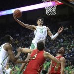 Oregon's Miles Norris, center, shots over teammate Francis Okoro, left, and Arizona's Chase Jeter, center, and Ryan Luther, right, during the first half of an NCAA college basketball game Saturday, March 2, 2019, in Eugene, Ore. (AP Photo/Chris Pietsch)